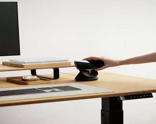 A professional adjusting the monitor distance at a clean ergonomic desk